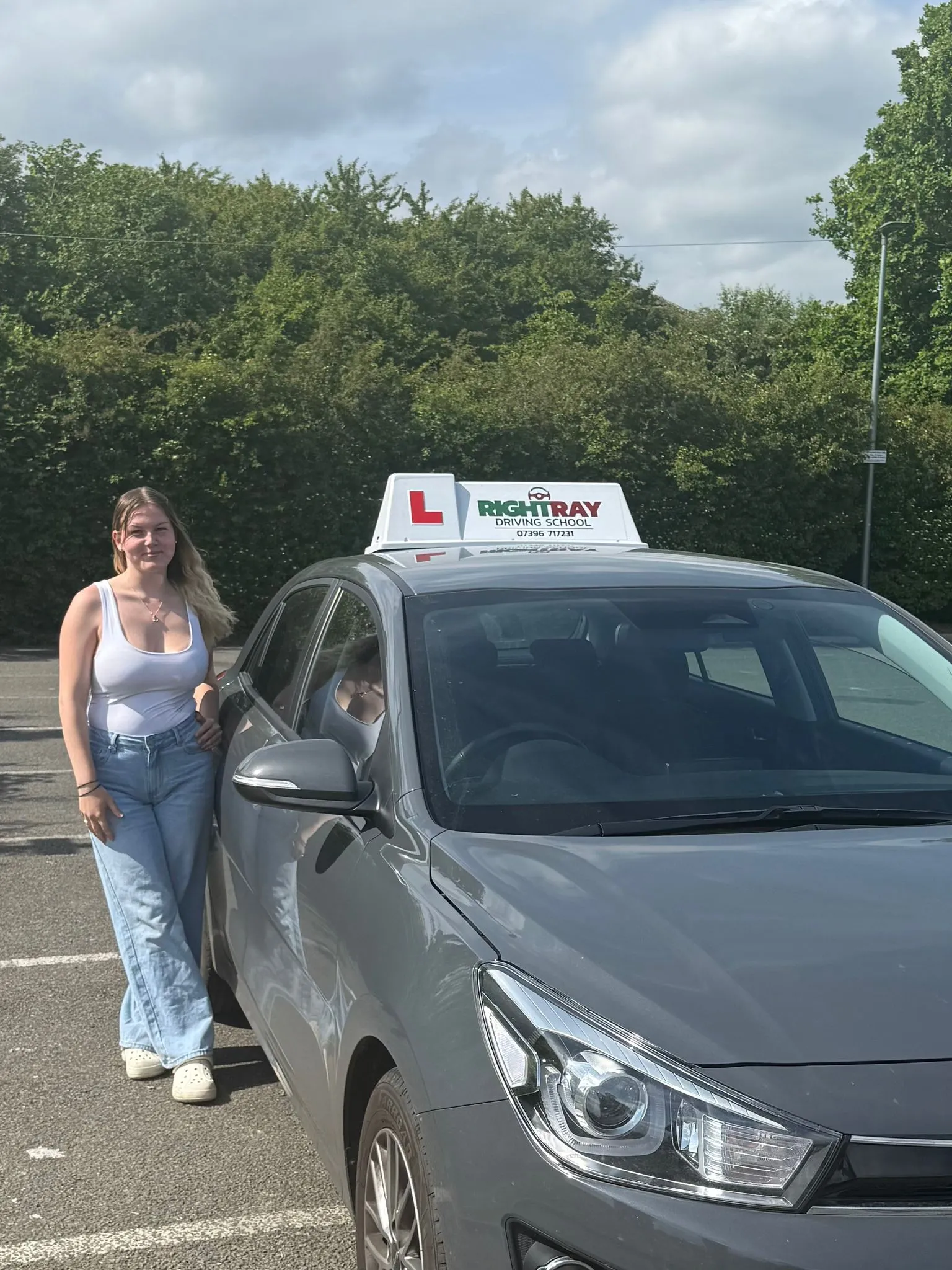 Katie standing beside a RightRay driving school car